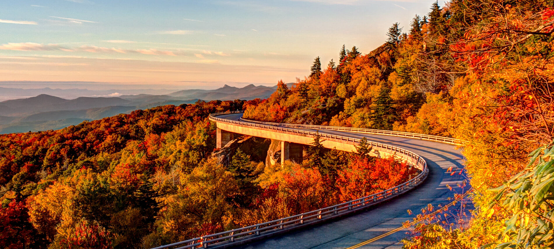 View of the Blue Ridge parkway. Vibrant colors are on the trees.. green, ted, orange, yellow. Mountains seem to go on for miles..